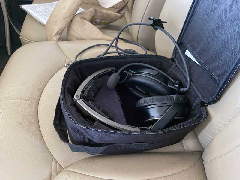 Bose A20 headset stored in its open carry bag on a seat