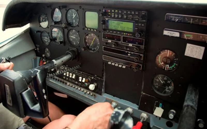 Pilot's hand on the transponder in a light aircraft instrument panel